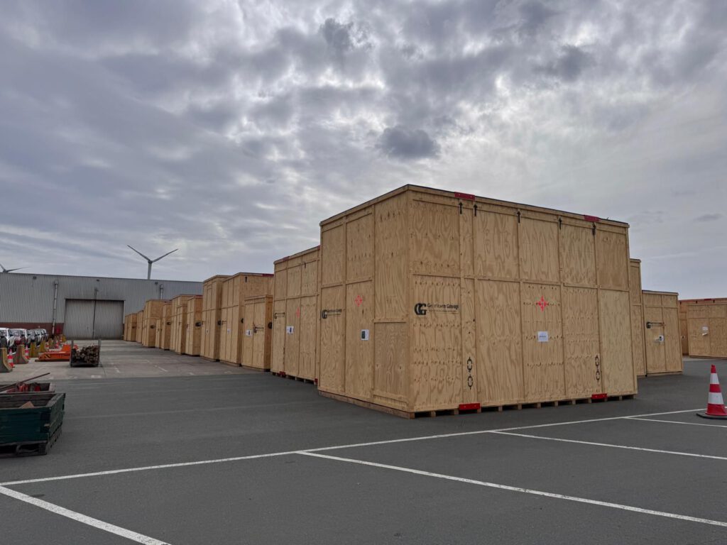 Multiple oversized custom crates in a harbour location. 